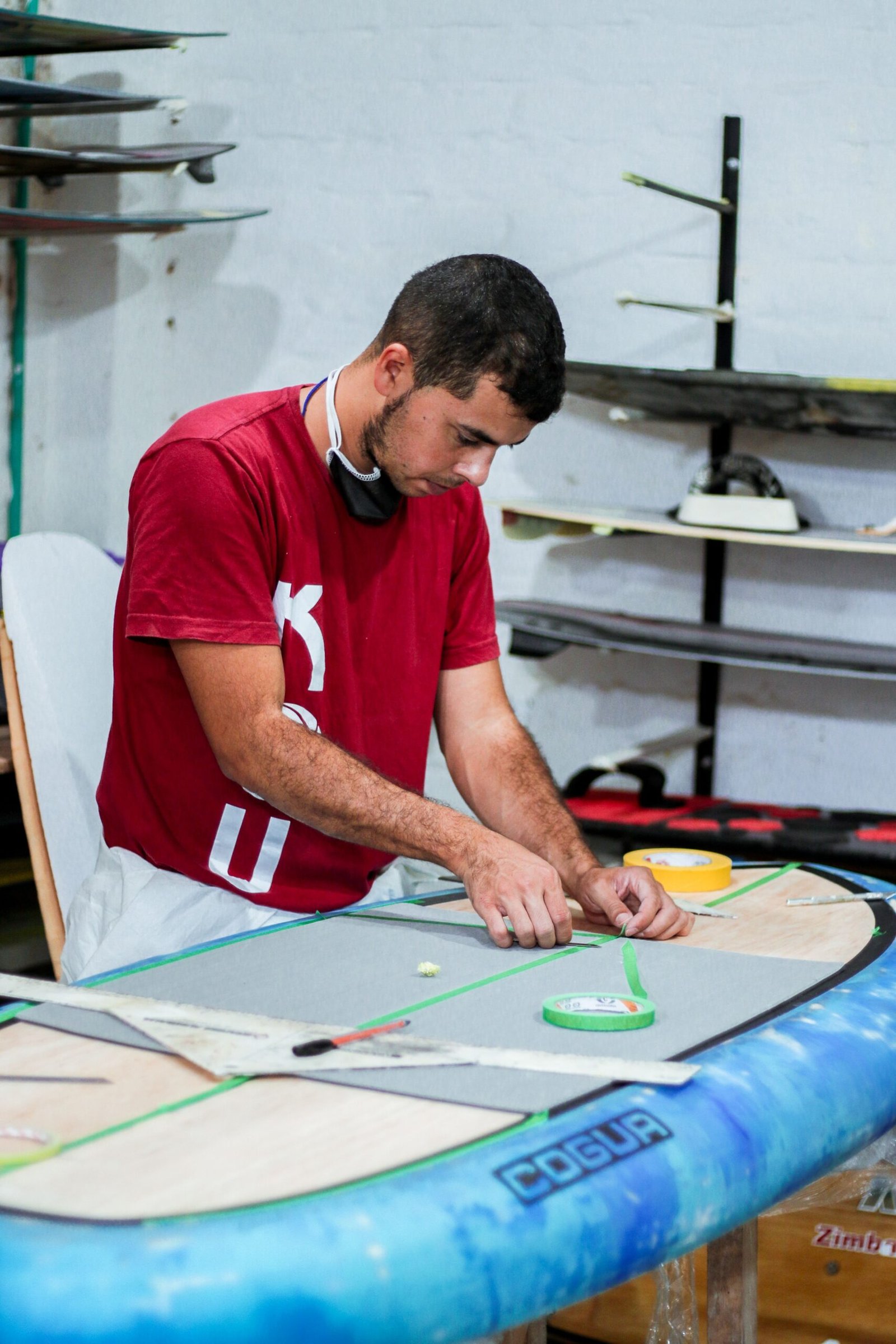 Atelier de réparation d'une planche de surf, résine appliquée sur un ding
